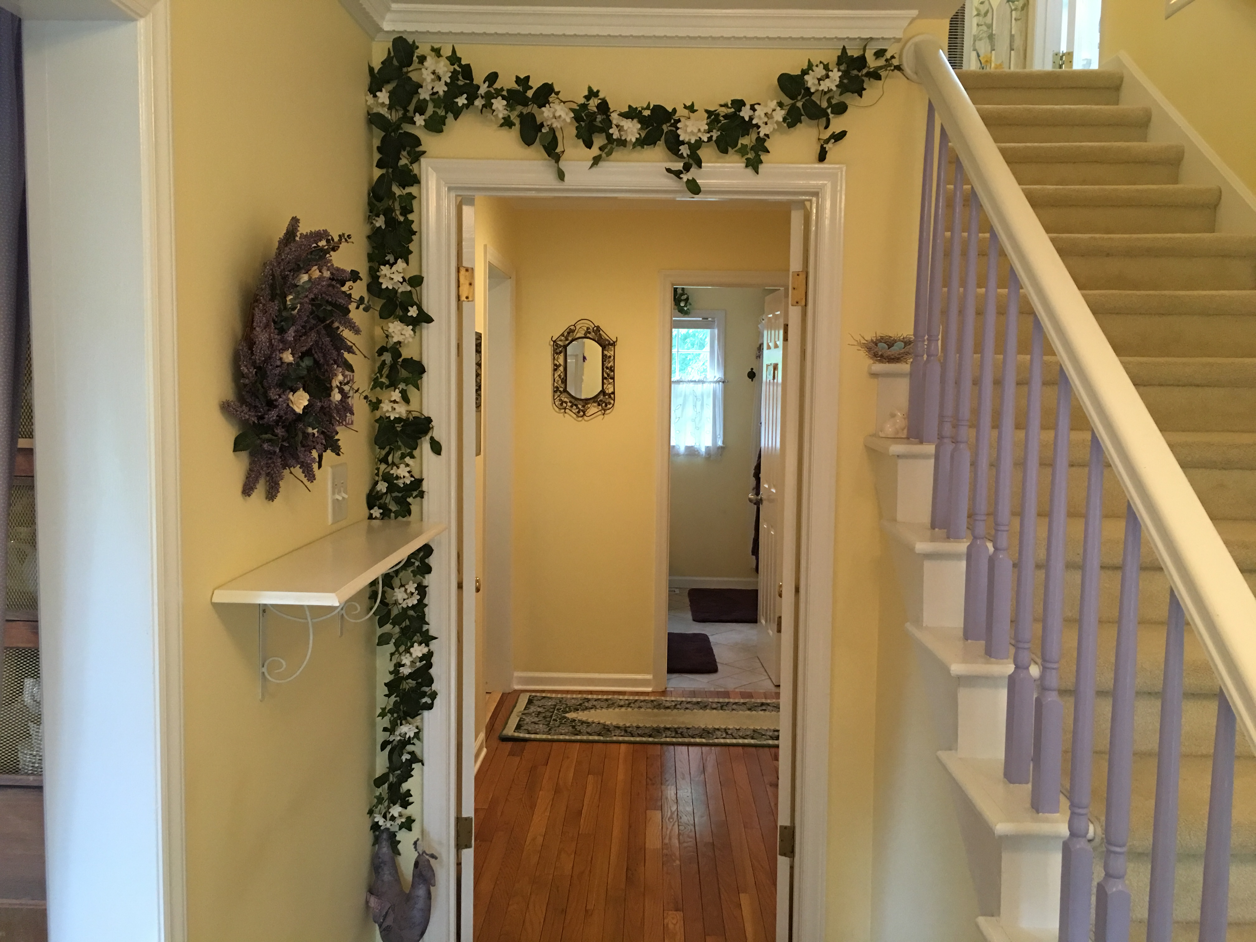 Step through the front door into the foyer of GardenSpirit with soft yellow walls and a floral motif.