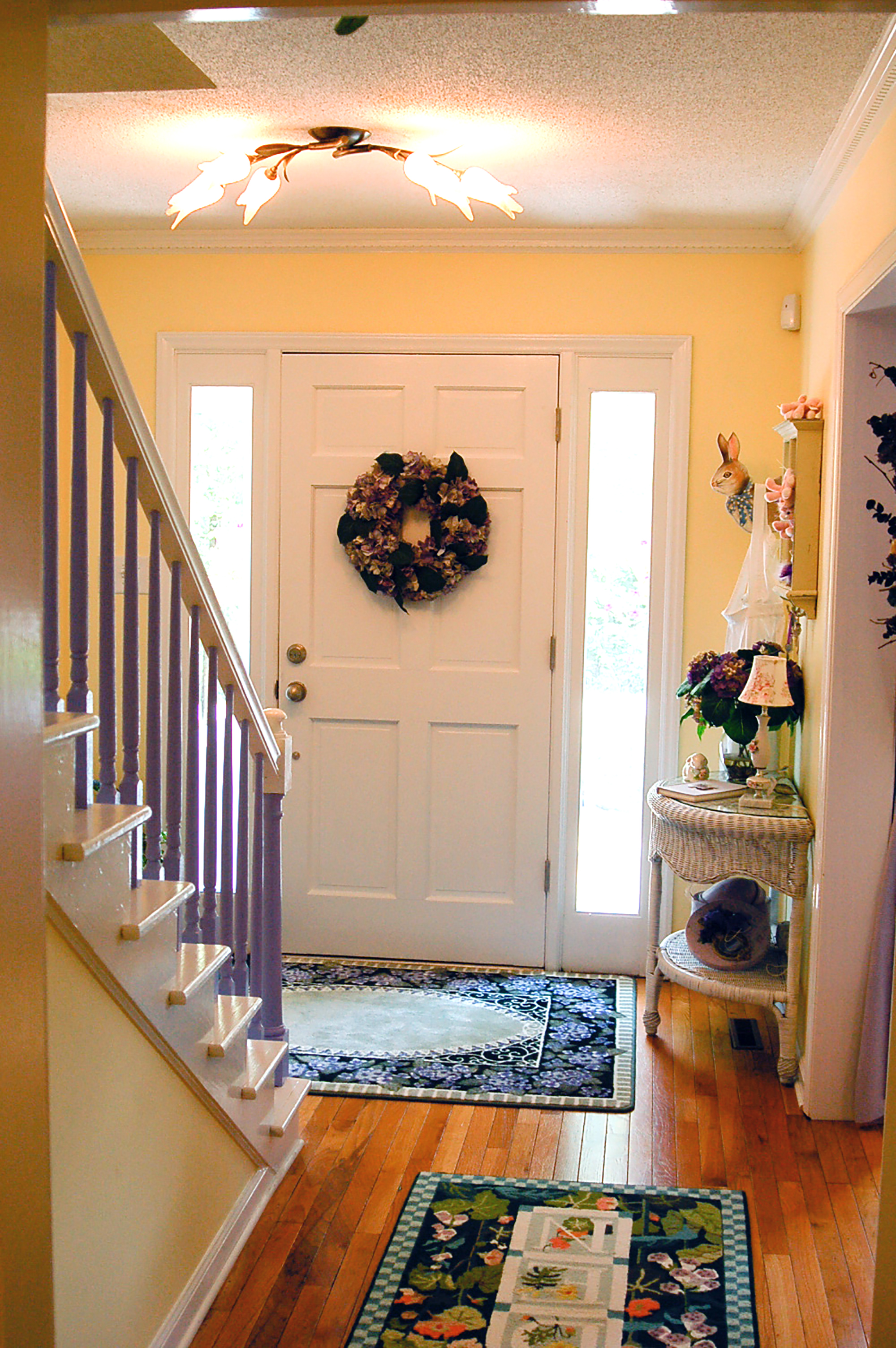 Foyer with a purple staircase and garden rugs.